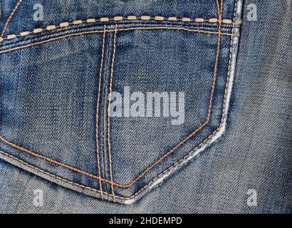 Worn denim blue fabric on back pocket of vintage jeans close-up Stock Photo
