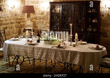 Beautiful shot of a table set for Christmas with a vintage cupboard in the background Stock Photo