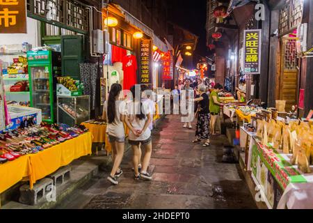 FURONG ZHEN, CHINA - AUGUST 11, 2018: Night view of a narrow alley with various stalls in Furong Zhen town, Hunan province, China Stock Photo