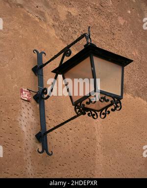 Old Lamp lantern iron black hanging on an old wall, home outdoor decoration in Albarracin, Spain Stock Photo