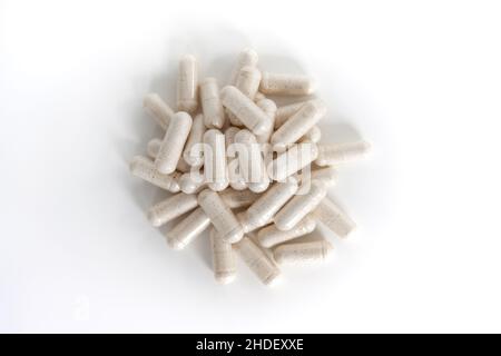 A pile of white multivitamin supplements from above isolated on white background. Stock Photo
