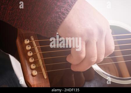 man playing guitar, hands on strings close-up Stock Photo