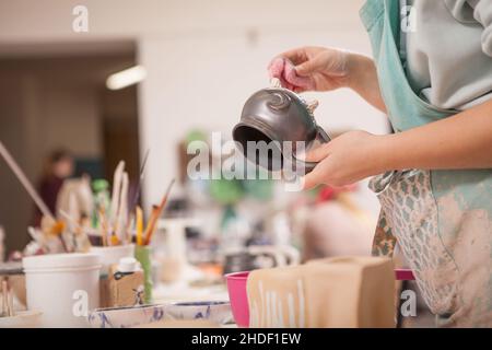 Cropped shot of unrecognizable female potter making kitchenware mug at her art studio Stock Photo