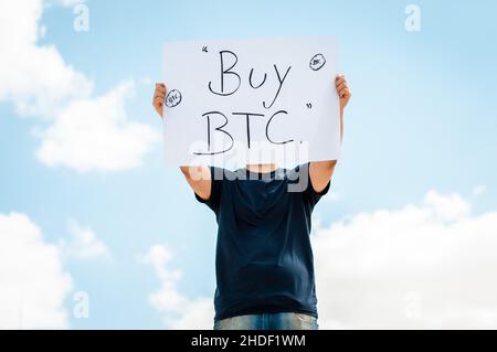 man with a sign that says buy bitcoin Stock Photo