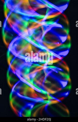 Vertical shot of colorful light trails against a dark background Stock Photo