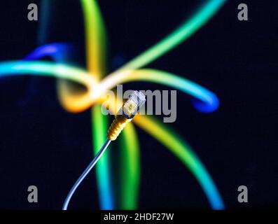 Internet cable and yellow ethernet connector in close up against a colourful background. Stock Photo