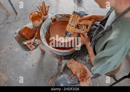 Diligent craftswoman making bowl in pottery workshop Stock Photo
