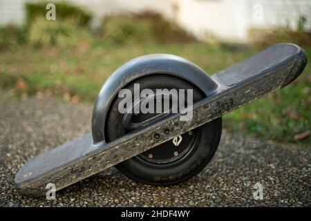 Closeup of a Onewheel Pint bicycle on an asphalt background with blurred grass background Stock Photo