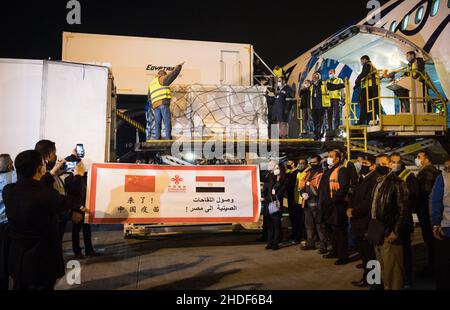 (220106) -- BEIJING, Jan. 6, 2022 (Xinhua) -- Workers convey a batch of Sinopharm COVID-19 vaccines donated by China at Cairo International Airport, Egypt, Feb. 23, 2021. (Xinhua/Wu Huiwo) Stock Photo