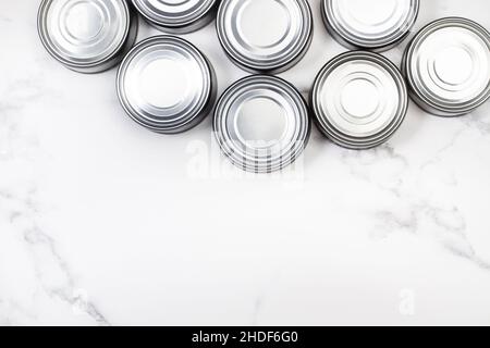 Cans of preserves on a marble background with copy space in a top view Stock Photo