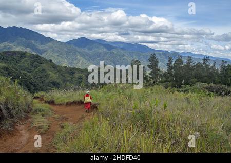 Papua New Guinea; Eastern Highlands; Goroka; Namta; Papuan woman on a dirt road in the mountains. Papuanische Frau auf einem Schotterweg in den Bergen Stock Photo