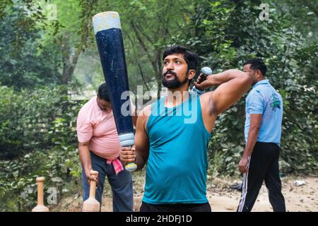 Unidentified Indian wrestlers do exercise by lifting their traditional equipments near ganga Ghat in Varanasi, Uttar Pradesh, India. Stock Photo