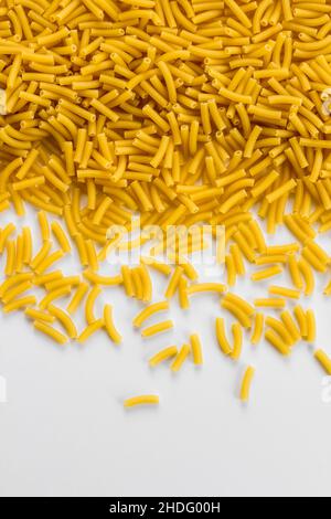 Uncooked,short cut pasta on white background with copy space Stock Photo