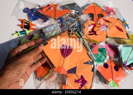 Female hand holding Kite and shopping during Indian kite festival Makarsankranti or Uttarayan. Many kites in packets sold in India Stock Photo