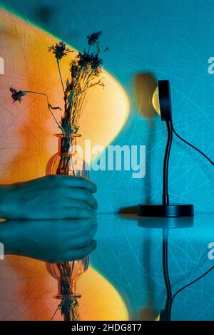 Sunset projector lamp on the table. Multi colored RGB light. Home decor. Selective focus Stock Photo