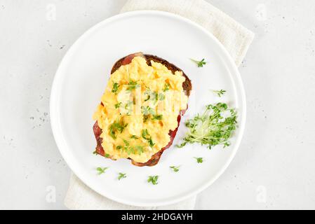 Scrambled eggs with microgreen on bread.  Top view, flat lay Stock Photo