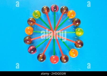 Various colorful lollipops on pastel background. Bright juicy colored lollipops on a light blue background. Lollipops in the form of a flower. Fruit Stock Photo