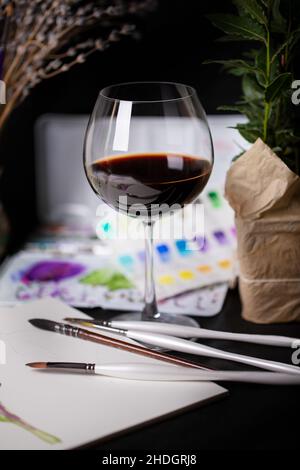 Cozy still life with wine and watercolor paints Stock Photo