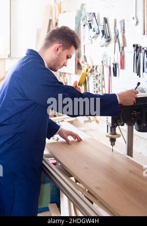 guy using drilling machine at workshop Stock Photo