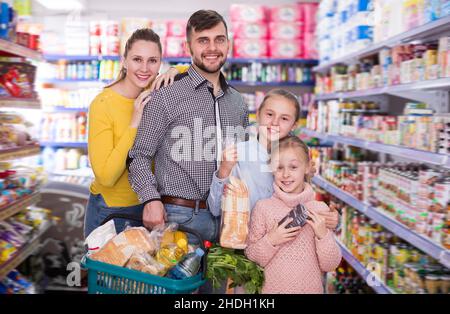 Cheerful family of four with full basket Stock Photo