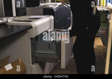 Worker with modern big print machine in print house. Printing industry concept background Stock Photo