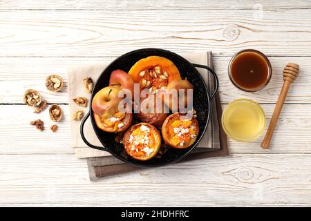 Concept of tasty food with baked apples on white wooden table Stock Photo