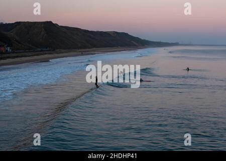 SALTBURN BY THE SEA, UK - 1 JANUARY 2020.  Surfers on Saltburn Beach at Sunrise on New Years Day 2020 Stock Photo