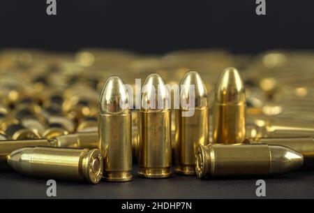 Many brass gun bullets on black table closeup view, Stock Photo