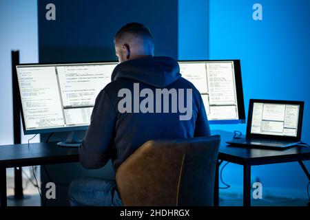 Hacker Using Computer To Write Cyber Security Exploit Software Program Stock Photo