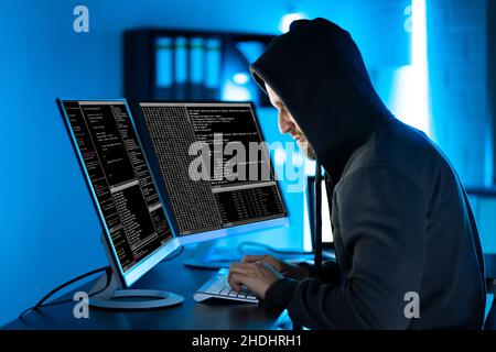 Hacker Using Computer To Write Cyber Security Exploit Software Program Stock Photo