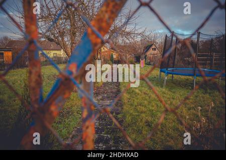 An allotment garden behind a rusty old fence Stock Photo