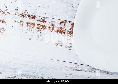 An empty round white plate on a blue wooden table. Top view Stock Photo
