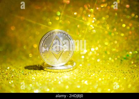 The reverse side is ether. Cryptocurrency ether is the coin of the future. Golden ether. Golden shiny background. High quality photo Stock Photo