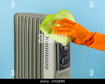 Hand wiping the oil filled electric heater with microfiber cloth. Сleaning  the space heater from dust. Household chores, cleaning and housework Stock  Photo - Alamy