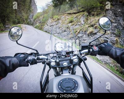 Hitting the road through a canyon with a classic and fast motorcycle Stock Photo