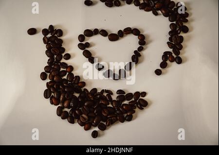 Heart laid from coffee beans on white background Stock Photo