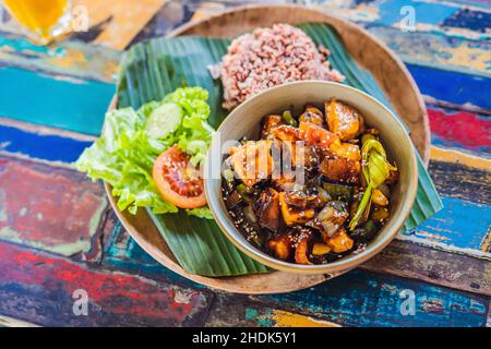 Popular Balinese meal of rice with variety of side dishes which are served together with the rice and more as optional extras Stock Photo