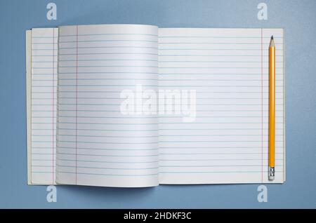 Opened school notebook and pencil on blue desk, top view Stock Photo