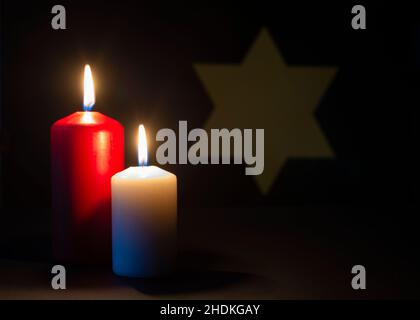 Two Burning candles and the star of David in the background. Holocaust remembrance day. Stock Photo