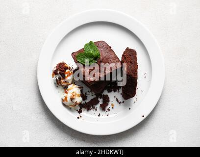 Plate with pieces of tasty chocolate brownie and ice cream on white background Stock Photo