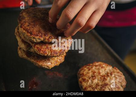 Close-up of a grill where hamburger meat is cooked, beef is cooking, nice atmosphere in the kitchen. Stock Photo