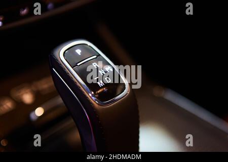 Automatic gear stick of a modern car, multimedia and navigation control buttons. Car interior details. Transmission shift. Shallow dof Stock Photo