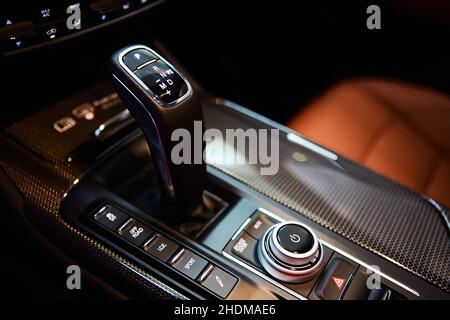 Automatic gear stick of a modern car, multimedia and navigation control buttons. Car interior details. Transmission shift. Shallow dof Stock Photo