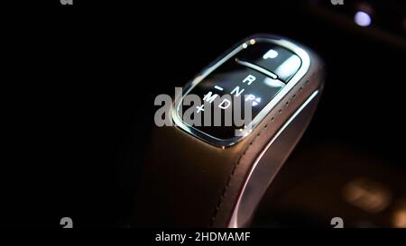 Automatic gear stick of a modern car, multimedia and navigation control buttons. Car interior details. Transmission shift. Shallow dof Stock Photo