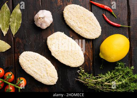 Fish cutlets from minced cod set, on old dark wooden table background, top view flat lay Stock Photo