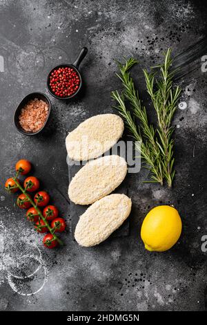 Round fresh fish cakes, on black dark stone table background, top view flat lay Stock Photo