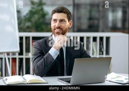 Attractive confident influential caucasian bearded businessperson, ceo of company, top manager, in formal suit, sitting in modern office, looking to the side, thinking strategy, smiling friendly Stock Photo