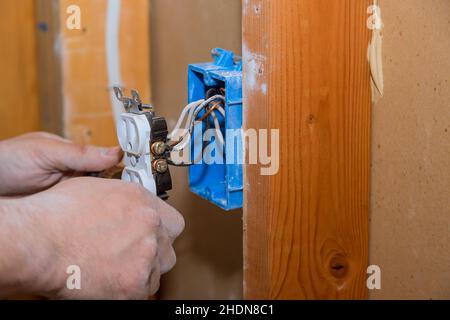 Preparing to remove an electrical outlet of the screws for electrical wires Stock Photo