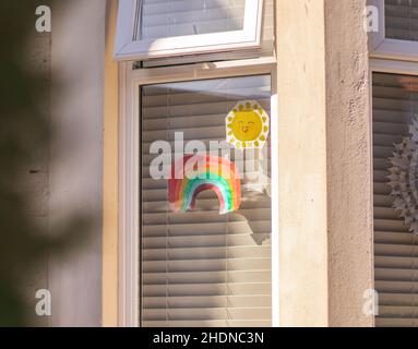 Shot of rainbow and sunshine drawing on a glass window Stock Photo