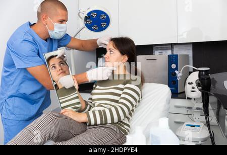 Cosmetician explaining hardware facial procedure to female client Stock ...
